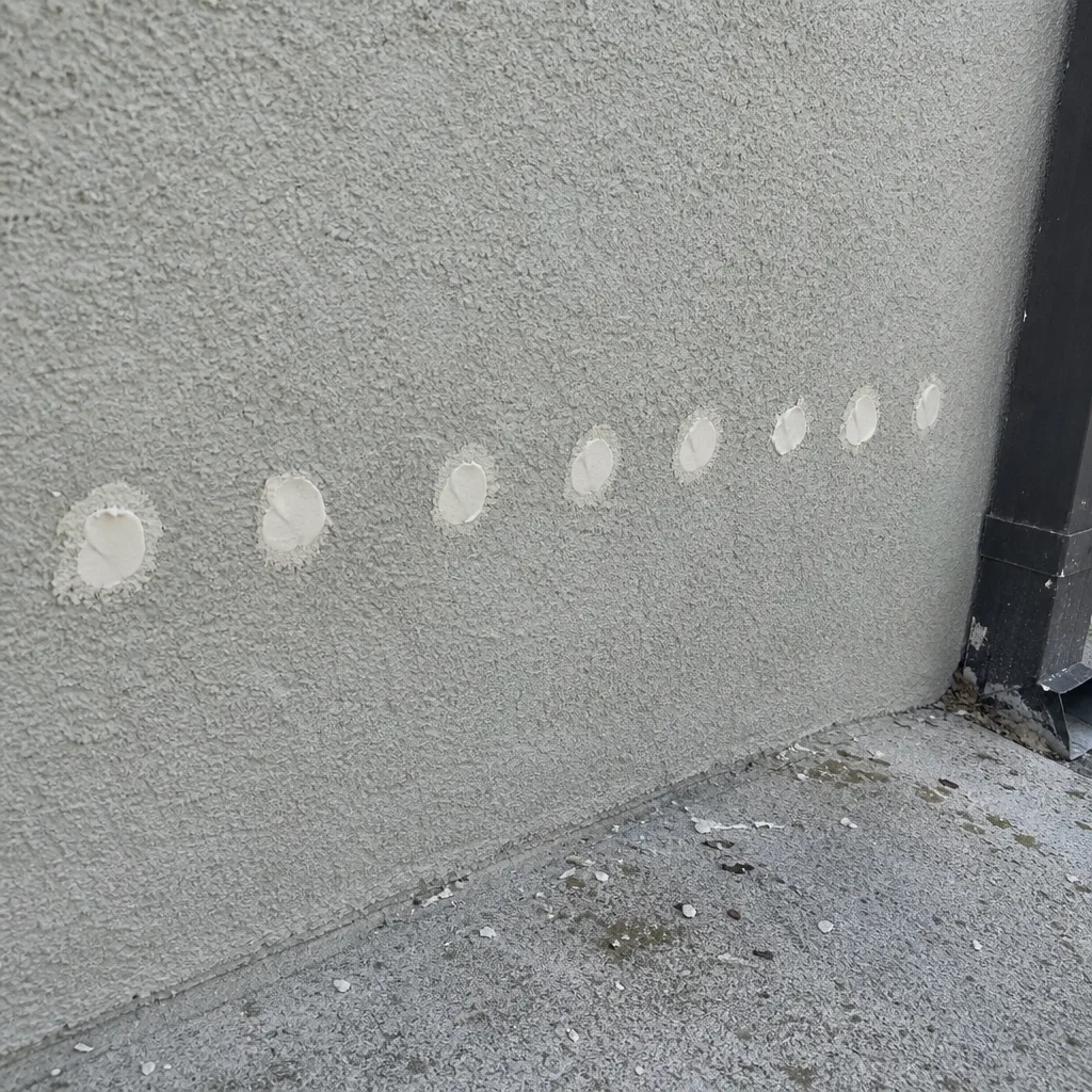 Foam injection points on a stucco wall for residential wall insulation nationwide